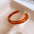 Macro shot of amber translucent resin open bangle with caramel fluid textures - 29# Highly Transparent Caramel Open Bangle (Amber)