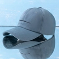 Detail of grey-blue baseball cap with black 'freedom' script embroidery on cotton fabric - One Size / Blue