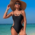 Sexy black one-piece swimsuit with side cut-outs and tie details on a sunny beach - Black