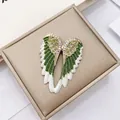 Macro shot of angel wing brooch with green gradient enamel and sparkling rhinestones - Angel Wings Brooch - Green