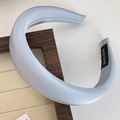 Close-up of light blue satin headband showing smooth texture and handmade label detail - Blue Gold