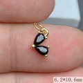 Detalle macro de un colgante de corazón dorado de 6,2x10,6mm con piedras negras en dedos - Negro