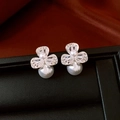 Close-up of elegant flower pearl earrings with zircon inlay on a luxury display stand - Silver
