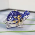 Macro shot of small turtle figurine made of blue resin with gold leaf and white crystal - Blue Glass + Gold Foil