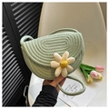 Detailed macro of a light green woven bag featuring a cute white daisy flower ornament - Green
