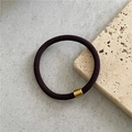 Detail view of high elasticity hair tie with ribbed fabric and matte gold metal connector - Dark Coffee
