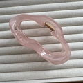 Detailansicht einer großen, durchsichtigen rosa Haarklammer in Wolkenform auf Beige - Gelee Rosa