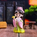 Close-up of Q-version female figurine in pink and green Hanfu holding a gold bird - Chen Yuanyuan