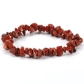 Macro view of red jasper natural stone chip bracelet with elastic cord texture - Ruby Red