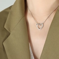 Unisex silver heart pendant necklace on snake chain shown on a green blazer model - Hollow Heart Pendant (P1339) / Steel Color (40+5cm)