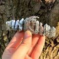 Macro shot of silver metal wrapped raw crystal crown with moon and star pendants - Silver