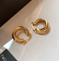 Detailed macro view of gold-plated twisted hoop earrings with micro-paved zircon stones - Gold