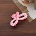 Elegant pink bow hair claw clip for women with a glossy finish on a wooden surface - Bow Claw Clip / Pink