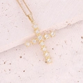 Macro view of 18K gold plated cross pendant featuring micro-pave zircons on stone surface - White