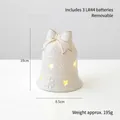 Ivory ceramic Christmas bell with gold bow, LED light, and cutout star patterns - Bell
