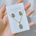 Detailed close-up of golden necklace and earrings set with oval blue gemstones - Gold Light Blue Stone Set (O)