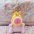 Cute pink plush Capybara keychain wearing a bright yellow hood with a golden metal hook - Dragon Horn Hat Pink + Gold Clip