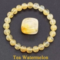 Macro detail of tea watermelon quartz beaded bracelet with a square stone on black background - Watermelon Quartz