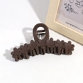 Macro detail of a 13cm dark brown matte flower hair claw with seven floral designs - Brown