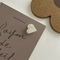 Close-up of heart-shaped pearlescent hair claw clip on book with French text detail - Small Heart Claw Clip