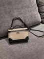 Detail of beige canvas and black leather crossbody bag with silver hardware on grey sofa - Canvas Leather Splicing / Linen Black