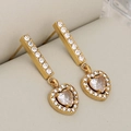 Orecchini a pendente a cuore in oro con zirconi brillanti su scatola beige - Cuore d'oro