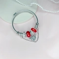 Detailansicht eines silbernen Charm-Armbands mit roten Glasperlen und Anhängern - Rot