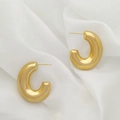 Detail shot of chunky gold U-shaped C-hoop earrings on a soft white silk background - Thick Tube C-Shape Style (XL1464-32)