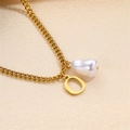 Elegant gold O-letter initial necklace with baroque pearl pendant on silk fabric - Letter O Necklace