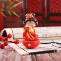 Detail van een tuimelaar figuurtje met fluit in traditionele rood-gele klederdracht - 1088-35 Fluit spelen (Groot) / 1088 Tumbler-serie