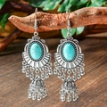 Macro shot of Bohemian silver earrings featuring turquoise stones and small bell tassels - Oval Turquoise Bell (HQEF-0158)