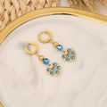 Orecchini a cuore dorati con occhio blu su vassoio di marmo e paglia decorativa - Design Cuore d'Oro