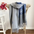 Blue and grey pashmina shawl with dandelion floral pattern and fringe edges on a chair - Dandelion Grey
