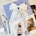 Elegant large white satin bow hair clip with long ribbons on a fashion magazine - Pure White