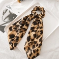 Close-up of a leopard print satin hair scrunchie with ribbon on a white tray and magazine - Light Brown Leopard