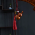 Detailed close-up of a wooden gourd keychain with vibrant red silk tassels and colorful beads - Aged Cypress Gourd Prosperity Red Tassel