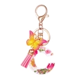 Portachiavi lettera C in resina con fiori secchi, ciondolo a farfalla e nappa rosa - Motivo Floreale C