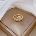 Macro d'une bague couronne cœur dorée avec zircon sur une boîte à bijoux brune - Ouvert Réglable / Style Cœur Couronne (R136) / Or 18K