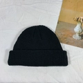 Classic black knitted beanie with cuffed brim on a minimalist decorative background - One Size / Black