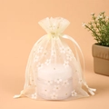Beige organza drawstring pouch with gold floral print containing a 50g cosmetic jar - Yellow