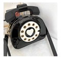 Macro shot of creative retro telephone crossbody bag in black patent leather with golden zipper - Black