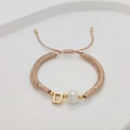 Detail of woven champagne cord bracelet with pearl and golden letter D charm - Letter D