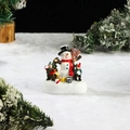 Detail of glowing Christmas snowman figurine with children on a snowy lighted base - Snowman & Kid
