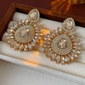 Detailed view of luxury gold sunflower earrings with pear-shaped crystals in a velvet box - Yellow