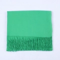 Grass green cashmere-like scarf featuring long tassels in a folded flat lay display - Grass Green