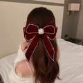 Detalle del lazo de terciopelo burdeos con perlas y pedrería en el cabello de una modelo - 36# Pasador de tela - Estándar - Lazo rojo vino