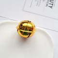 Cascabel metálico dorado con calados de estrellas sobre un plato de cerámica - 30MM / Dorado
