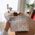 Detail van gewatteerde bloemen make-uptas met simple wish label in een knusse setting - Blauw Bloemen Gewatteerd