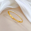 Primer plano de brazalete de acero de titanio dorado con pavé de circonitas blancas - Dorado (N429)