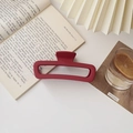 Detail view of large matte red rectangular hair claw clip styled on a white table - Matte Large Square Wine Red